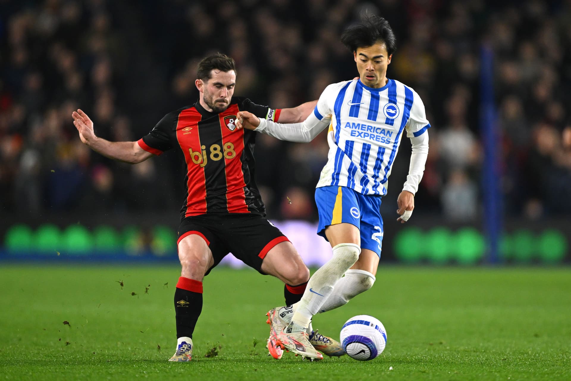 Kaoru Mitoma of Brighton & Hove Albion is challenged by Lewis Cook