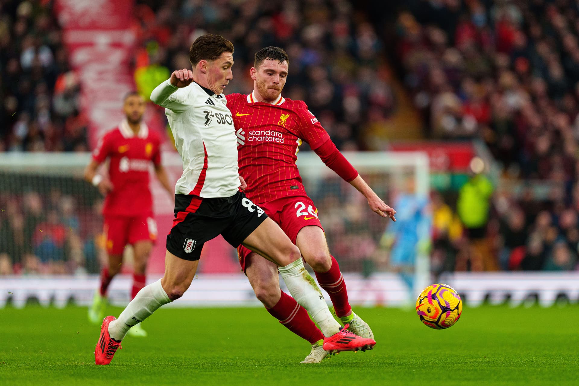 Liverpool's Andrew Robertson battles for possession with Fulham's Harry Wilson