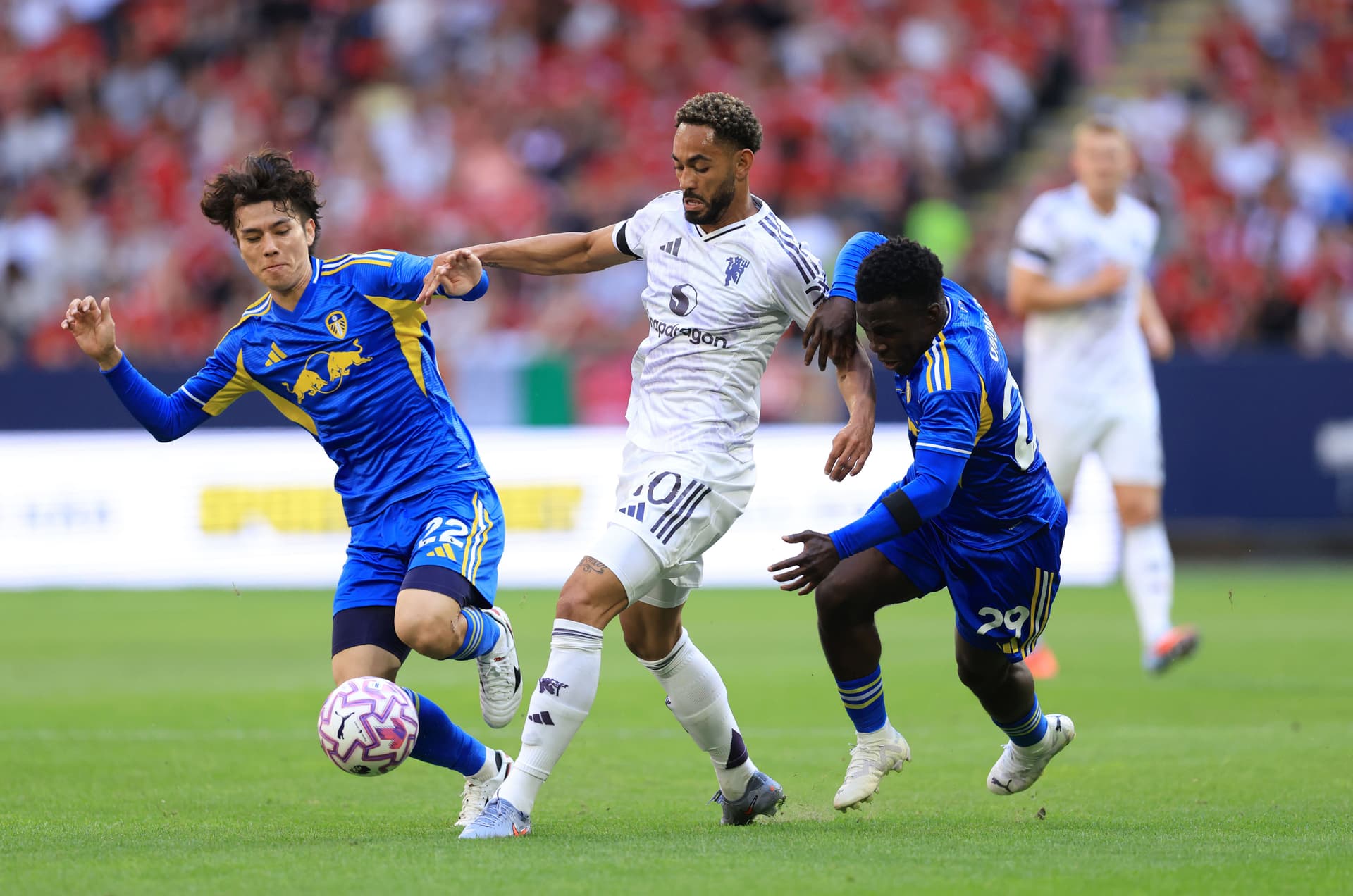 Matheus Cunha of Manchester United is tackled by Ao Tanaka oand Wilfried Gnonto