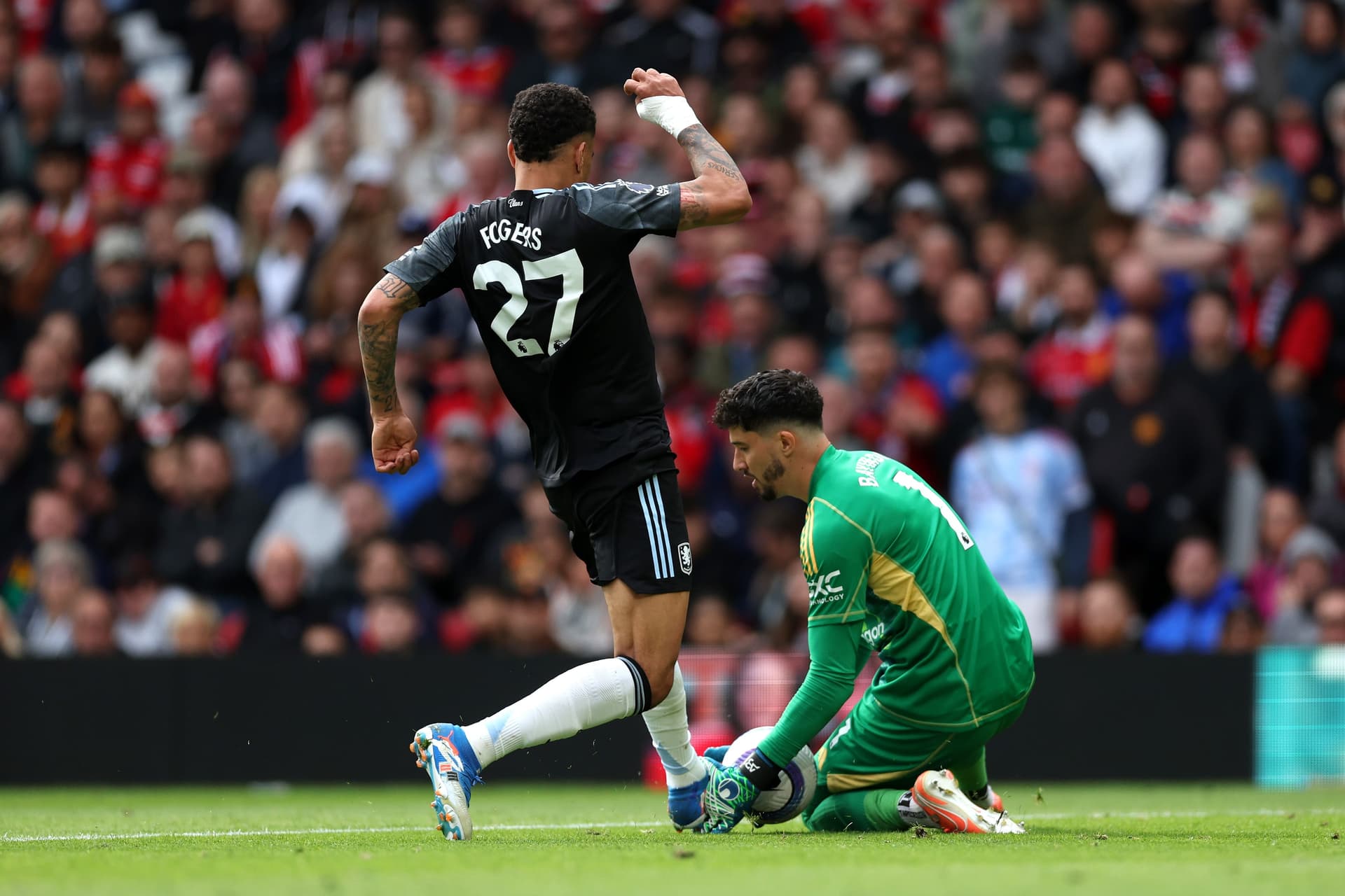Morgan Rogers of Aston Villa challenges Altay Bayindir of Manchester United