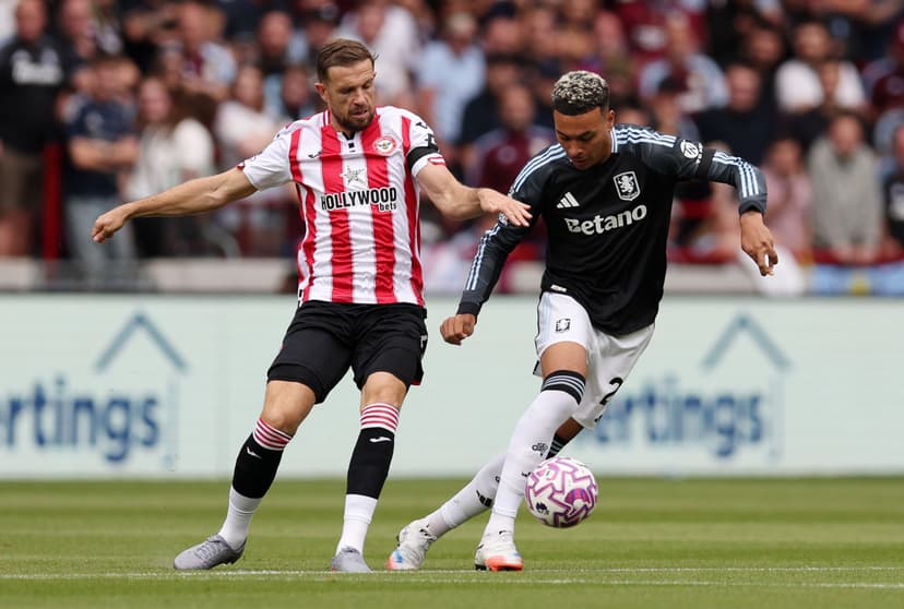 Morgan Rogers of Aston Villa is challenged by Jordan Henderson of Brentford